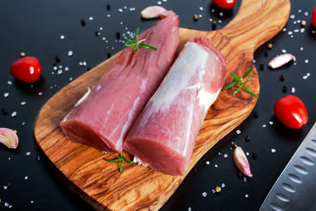 Fresh Raw pork tenderloin on wooden board .ready to cook.の写真素材
