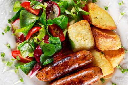 Roasted Sausages with Chips and Mix Vegetable salad.の写真素材