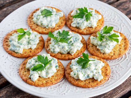 Bisquit cracker appetizers with cottage chees and parsley topping.の写真素材