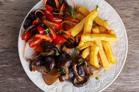 Summer dish with fried chips, red cherry tomatoe salad and grilled wild mushrooms.の写真素材