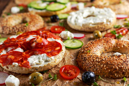 Delicious Bagel sandwiches with soft cheese, chorizo and vegetables.の写真素材