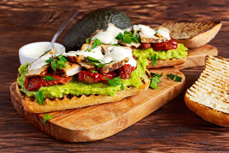Avocado Sandwich with sunshine dried tomatoes, roasted pork and sauce with herbs.の写真素材