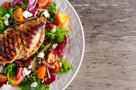 Grilled Chicken Breast fillet with fresh tomatoes vegetables salad. concept healthy foodの写真素材