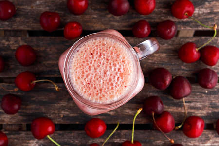 Cherry smoothie in jar glass on wooden table. healthy food concept for breakfast or snackの写真素材
