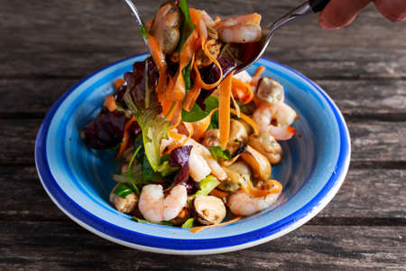 Mussel, shrimp and lettuce Asian style salad with sprinkle of chiliの写真素材