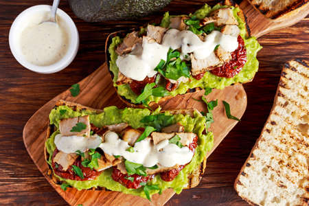 Avocado Sandwich with sunshine dried tomatoes, roasted pork and sauce herbsの写真素材