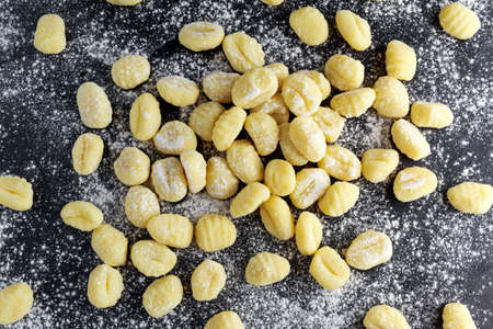 Uncooked homemade gnocchi on stone cutting floured boardの写真素材