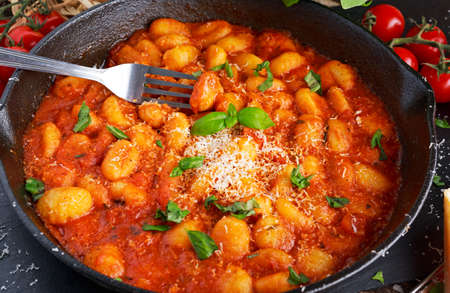 Homemade Italian Gnocchi with marinara sauce, cheese in iron pan.の写真素材