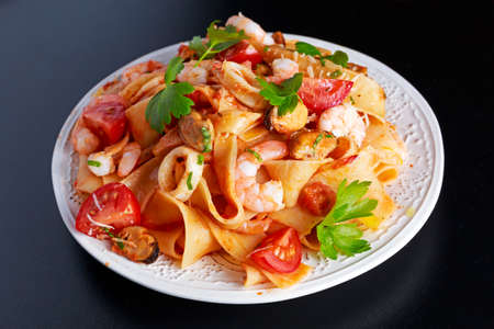 Tasty Pappardelle pasta with shrimp, Squid, mussel, tomatoes and herbsの写真素材