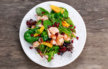 Fresh Salmon Salad with vegetables, pomegranate and orangeの写真素材