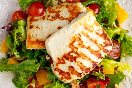 Grilled Halloumi Cheese salad witch orange, tomatoes and lettuce. healthy food.の写真素材