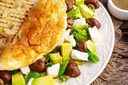 Mushroom, Feta Cheese egg Omelette witch Avocado, vegetables, lettuce, herbs and grilled bread