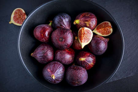 Figs on black plate on stone board.の写真素材