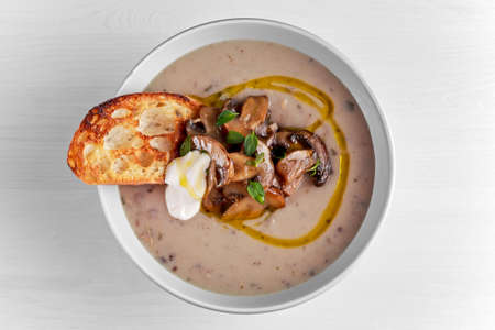 Mushroom soup with crouton and sour cream drizzled with olive oilの写真素材