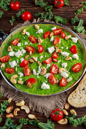 Vegetable Green Omelette with tomatoes, kale, greek cheese, olives, nuts, toast on wooden background. concept healthy food.の写真素材