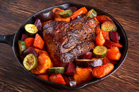 Oven baked Juicy pork loin with vegetables in griddle rustic pan.の写真素材