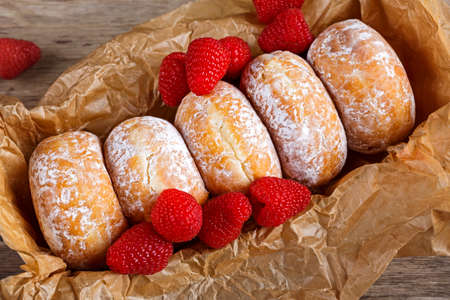 Fresh Raspberry jam doughnuts in icing sugar.の写真素材
