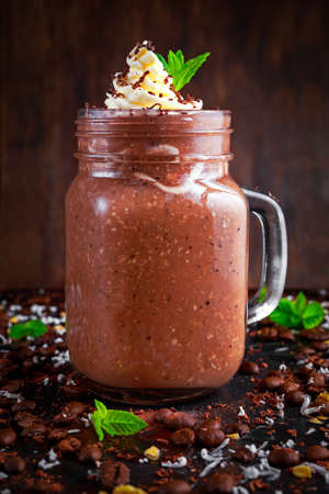 Coconut coffee chocolate smoothie with whipped cream on decorated table