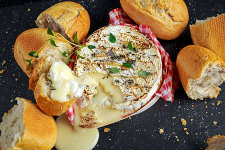 Homemade Baked Camembert cheese with thyme and fresh bread.