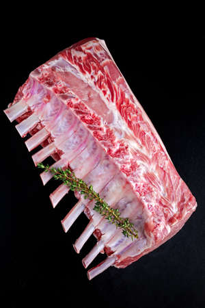 Fresh Raw French whole rack of pork loin with ribs on black board.の写真素材