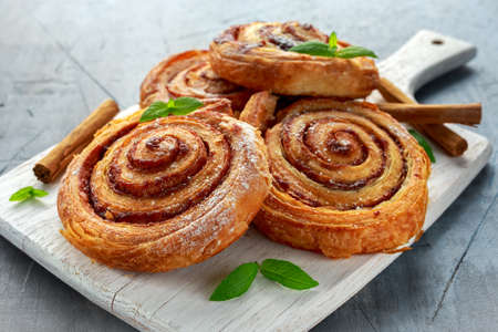 Freshly Baked Traditional Sweet Cinnamon Rolls, Swirl on white wooden boardの写真素材