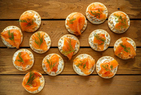 Smoked Salmon and soft chees canapes appetizers with chives on wooden table.の写真素材