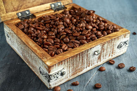 Coffe beans in open old wooden white chest.