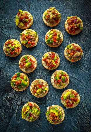 Salsa canape cracker appetizers with soft cheese.