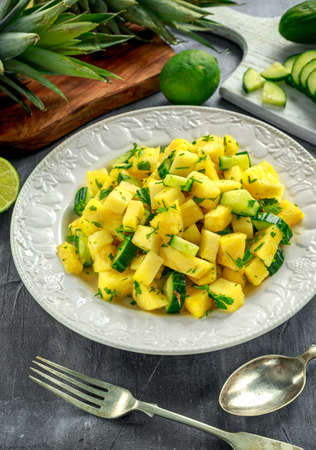 Fresh Juicy Pineapple Cucumber salad on white plateの写真素材