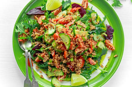 Quinoa tabbouleh salad with tomatoes, cucumber green onion. Concept healthy foodの写真素材