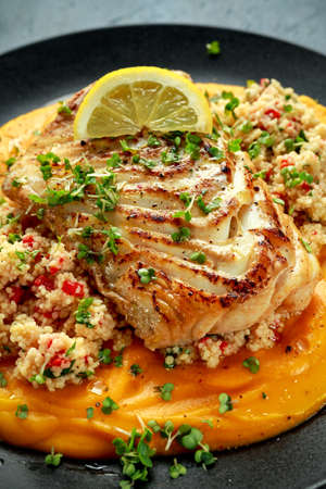 Soy-glazed cod loin fillet with cous-cous salad on butternut squash pureeの写真素材