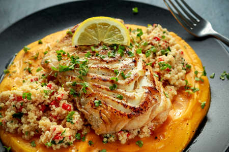 Soy-glazed cod loin fillet with cous-cous salad on butternut squash pureeの写真素材