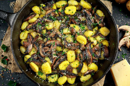 Home made potato gnocchi with mushrooms, chopped parsley and parmesan cheese in iron panの写真素材