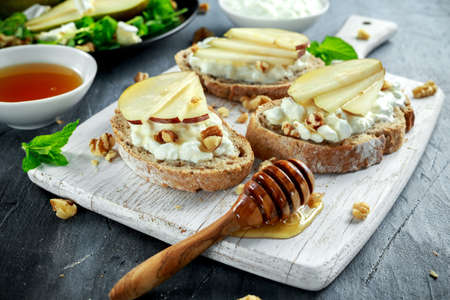 Fresh sweet Pears salad and bruschetta with cottage cheese, walnut on white board.の写真素材