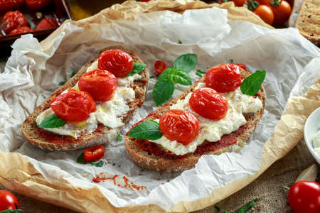 Tomato Ricotta Bruschetta with sun dried tomatoes paste, olive oil brown bread and basilの写真素材