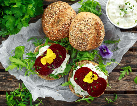 Rustic wholegrain buns with cottage cheese, rocket leaves, beetroot slices and edible viola flowers....