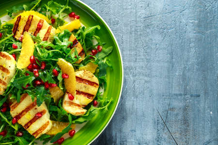 Grilled Halloumi Cheese salad with orange, rocket leaves, pomegranate and pumpkin seed. healthy foodの写真素材