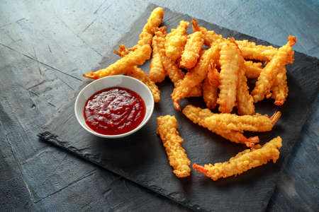 Fried Shrimps tempura with sweet chili sauce on black board stoneの写真素材