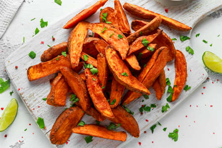 Healthy Homemade Baked Orange Sweet Potato wedges with fresh cream dip sauce, herbs, salt and...