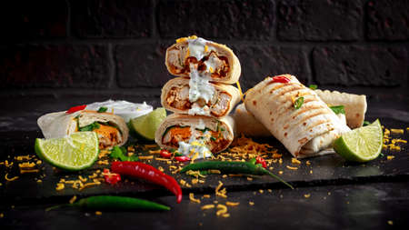 Healthy grilled chicken and parsley wraps, loaded with cheese, served with greek yogurt deep, chillies and lime slicesの写真素材