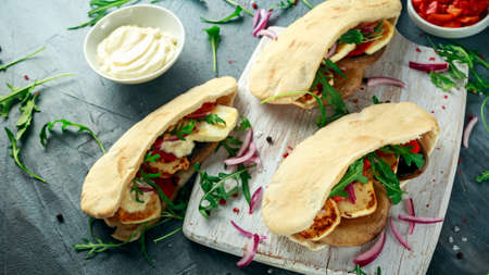 Stuffed mushroom and halloumi pittas with red pepper and onion in a white board.の写真素材