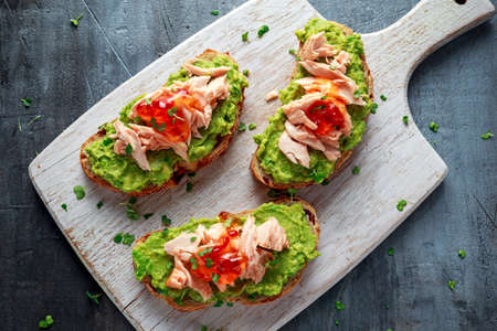 Homemade Toast sandwich with Salmon, Avocado and chilli jam on wihte wooden board. healthy foodの写真素材
