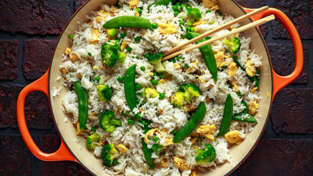 Fried rice with vegetables, broccoli, peas and eggs served in a pan. healthy foodの写真素材
