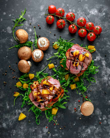 Duck breast steak slices on wild rocket pillow sandwich with orange bits, mushrooms and balsamic vinegar drizzleの写真素材