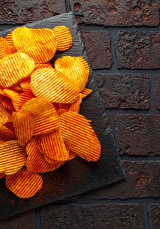 Potato chips, snack crisps with red paprika and white dip sauceの写真素材