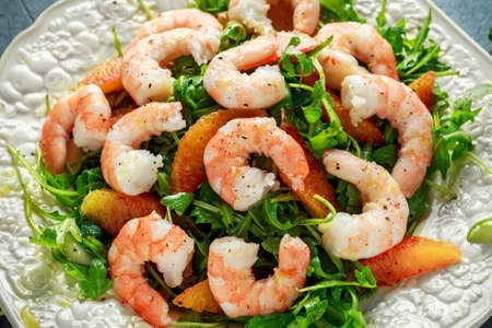 Asian style shrimp salad with wild rocket and blood orange served with lemon wedges and balsamic vinegar drizzleの写真素材