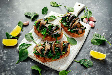Mushrooms and garlic sauteed spinach toasts With lemon wedges. healthy food.の写真素材