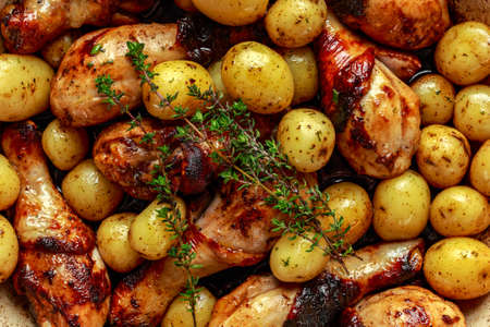 Oven baked Chicken drumsticks and new baby potatoes with thyme in pan, ready to serveの写真素材