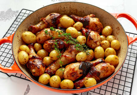 Oven baked Chicken drumsticks and new baby potatoes with thyme in pan, ready to serveの写真素材