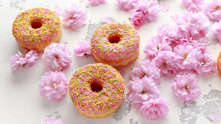 Sweet pink fresh Donut decorated with japanese Flowering Cherry Tree flower